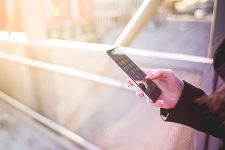 Young Woman Holding iPhone in Her Right Hand thumbnail