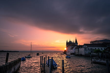 photo of white concrete buildings near sea during golden hour thumbnail