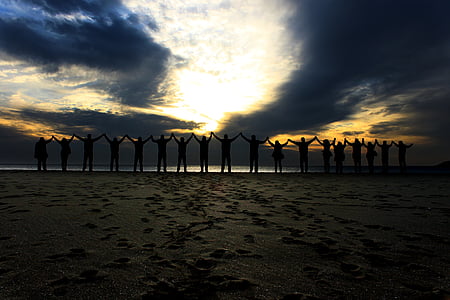 silhouette of group of people raising their hands thumbnail