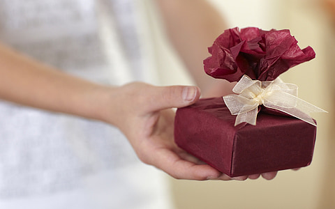 person holding maroon gift box thumbnail