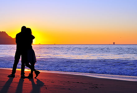 silhouette of man and woman beside body of water thumbnail