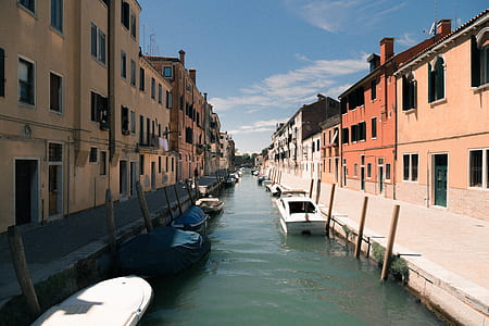 boat docked on river between establishments thumbnail