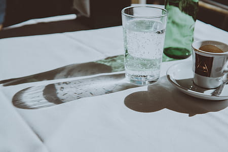 Clear Drinking Glass Beside Teacup thumbnail