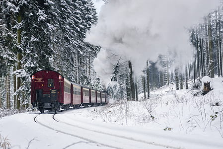 red train on snow covered train track during daytime thumbnail