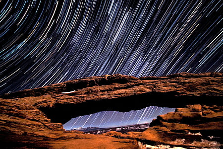 time lapse photography of rock formations and stars thumbnail