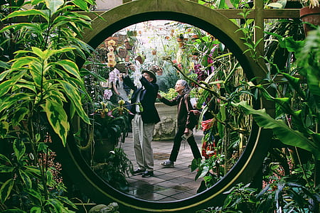 reflection of two women on round mirror near garden thumbnail