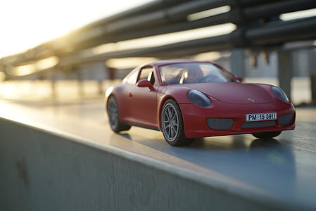 tilt shift lens photography of red car toy thumbnail