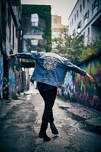 man in blue denim jacket standing on black-top road thumbnail