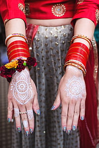 woman wearing red traditional Indian dress with mehndi arm tattoo thumbnail