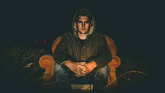 man sitting on brown couch thumbnail