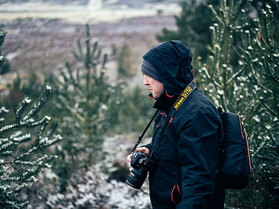 man holding black DSLR camera thumbnail
