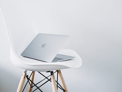 silver MacBook on wooden stoool thumbnail