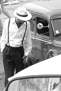 grayscale photo of man wearing white dress shirt standing beside the vintage car thumbnail