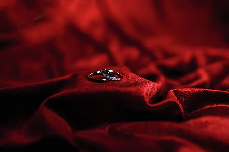 two silver-colored rings on red textile thumbnail