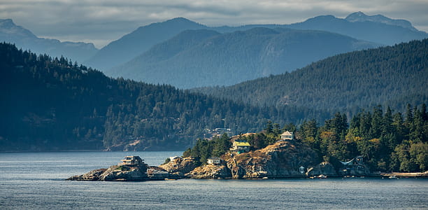 several white houses on top of cliff near body of water thumbnail
