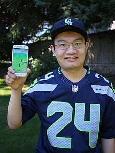 man holding a phone with Pokemon Go application running thumbnail