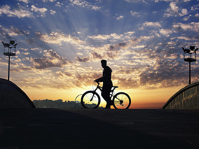 silhouette photography of man riding bike thumbnail