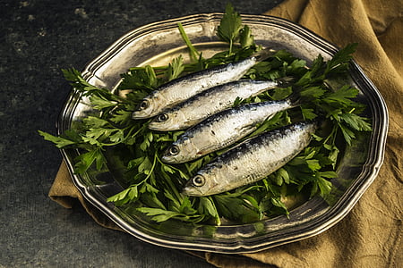 four silver fish on green vegetable leafs thumbnail