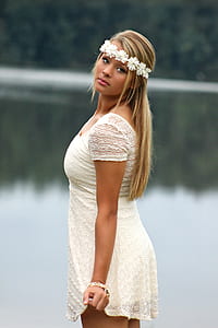 woman wearing white dress in front of body of water thumbnail