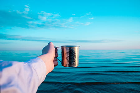 person holding stainless steel mug thumbnail
