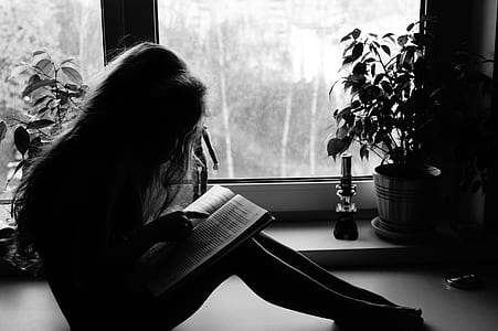 girl reading book in grayscale photography thumbnail