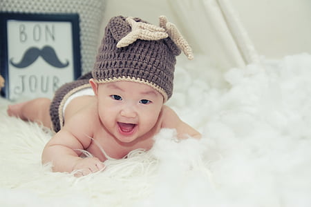 smiling pruning baby wearing knit cap thumbnail