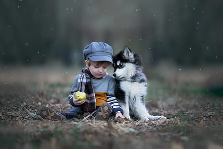 boy wearing gray sweater beside dog during daytime thumbnail