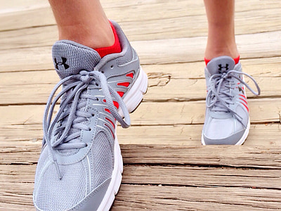 person wearing white-and-gray Under Armour lace-up casual sneakers thumbnail