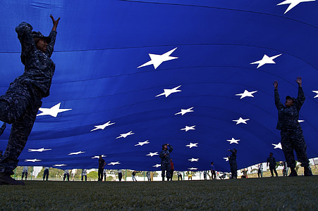 soldiers raising blue flag with white stars thumbnail