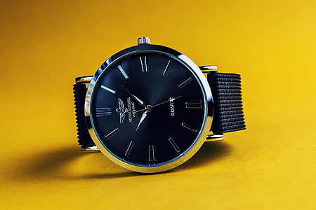 round blue face silver-colored analog watch on yellow surface thumbnail