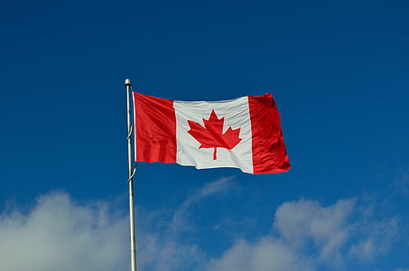 Canada flag in pole under blue and white sky during daytime thumbnail
