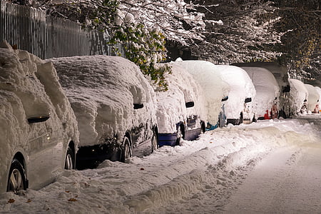 snow covered vehicles on the road during nighttime thumbnail