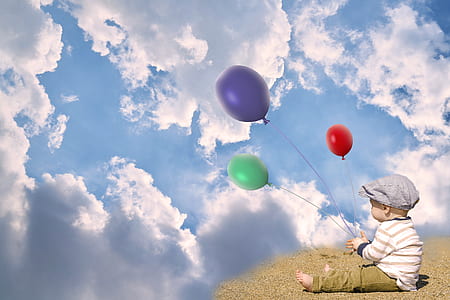 baby holding three green, purple, and red balloons thumbnail
