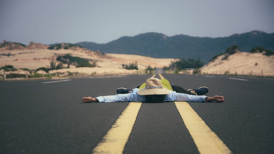 person lies on asphalt road thumbnail