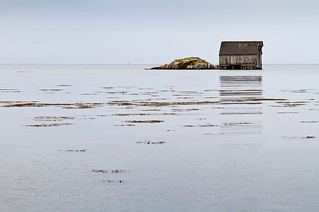 brown wooden house at the middle of the ocean thumbnail