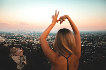 woman lifting her hands up overlooking city at daytime thumbnail