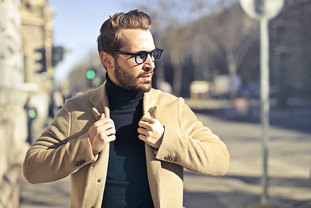man wearing brown parka holding his collar thumbnail