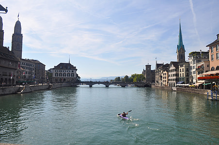 person riding kayak at the bay near the city during day thumbnail