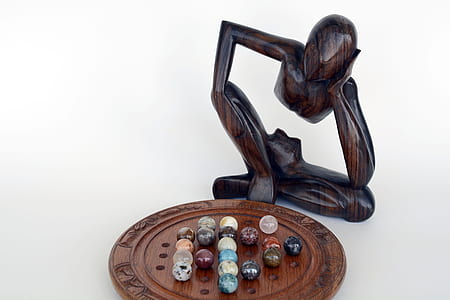 person sitting in front of board with marble figurine thumbnail