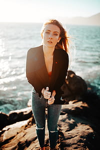 woman wearing black suit jacket and blue-washed distressed jeans thumbnail