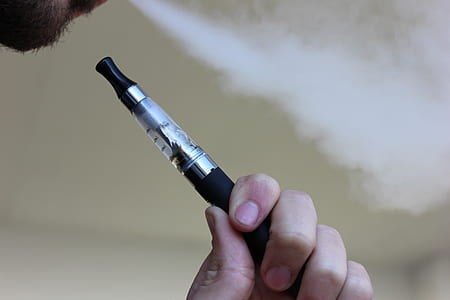 person holding black and gray vaporizer pen thumbnail