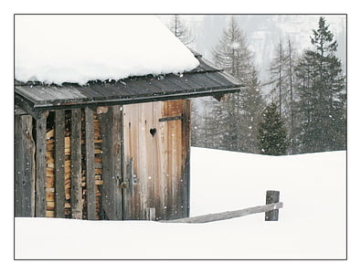 gray and beige wooden shed covered with snow thumbnail