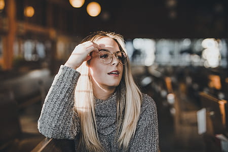 selective focus photo of a woman sitting on chair holding her eyeglasses thumbnail