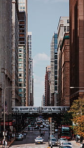 several vehicle passing between concrete buildings thumbnail