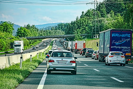assorted-color cars passing through grey road thumbnail