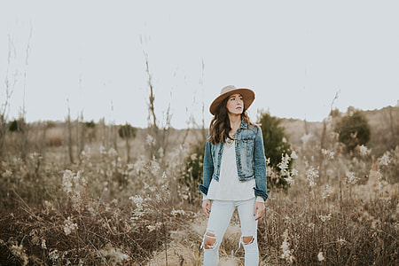 woman standing on wheat field under gray sky thumbnail