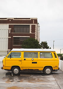 yellow van on gray pave road during daytime thumbnail