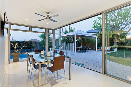 rectangular glass-top dining table near open door thumbnail