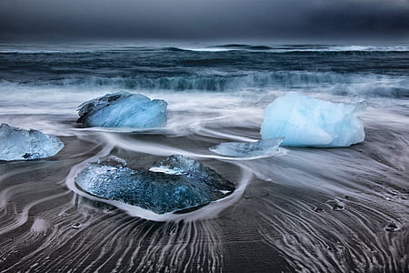 photography of ice rocks in the middle of body of water thumbnail