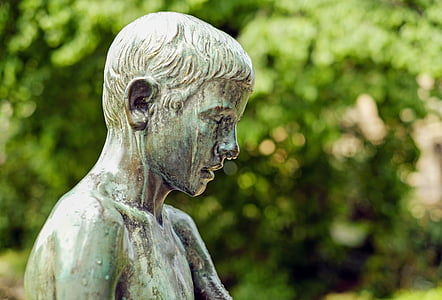 topless boy statue near green trees thumbnail